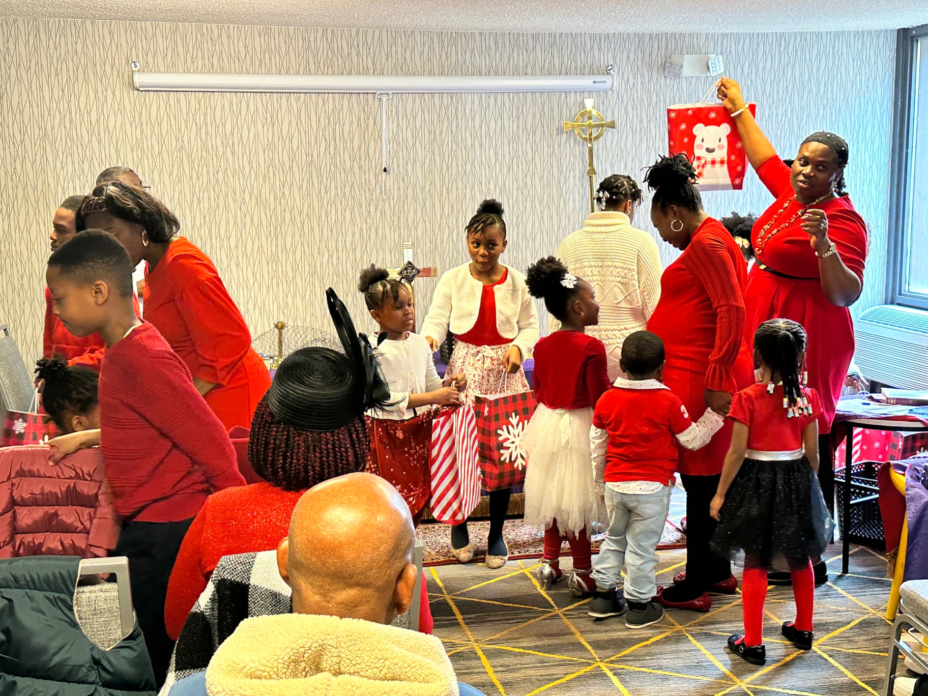 Children come forward to receive Christmas gift bags during the celebration.