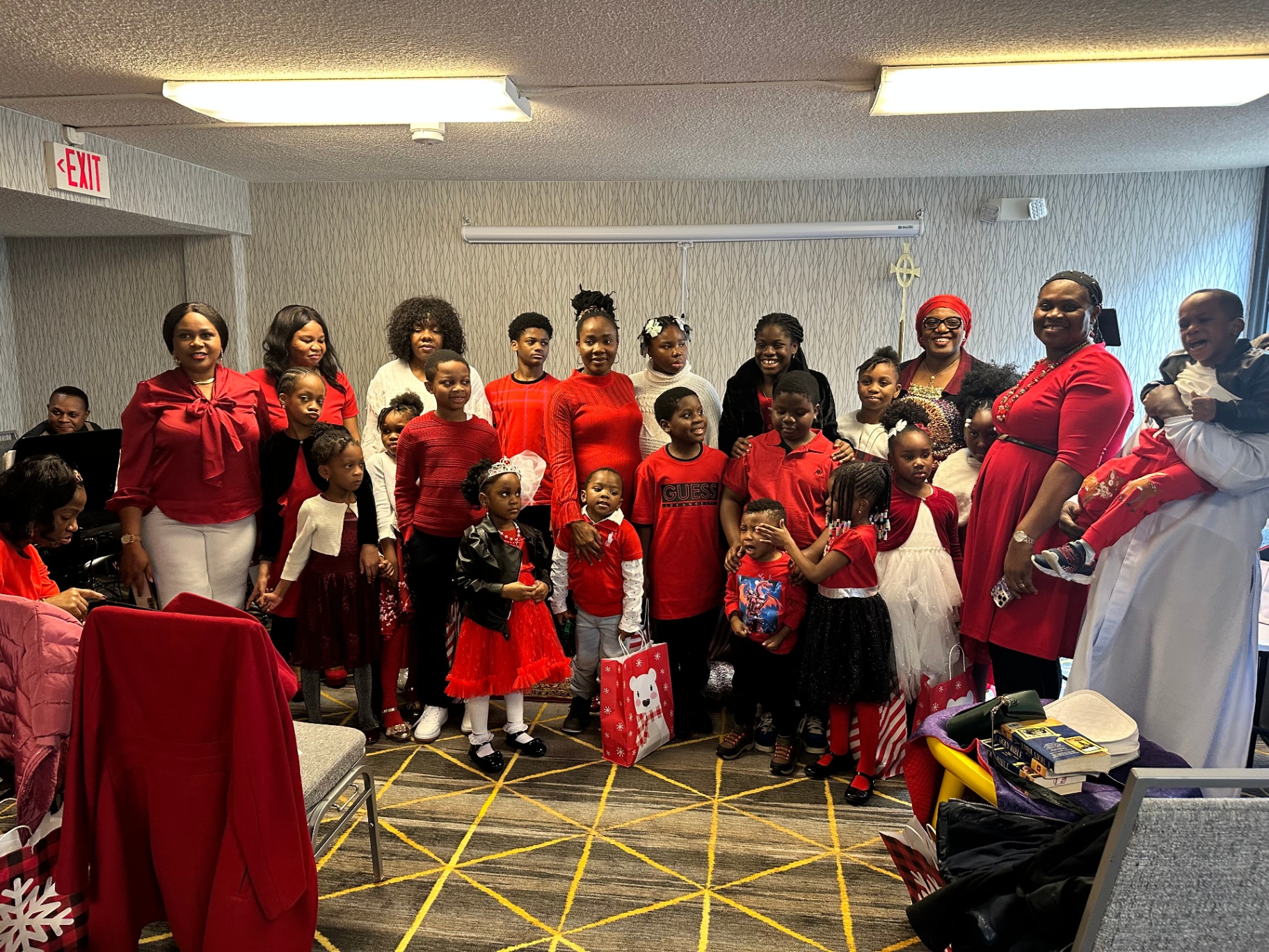 The whole family gathered around the altar — children and mothers dressed in Christmas red and white for the carol service.