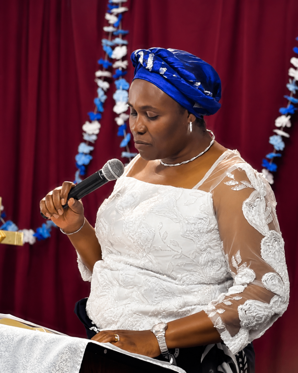 A women's ministry member reading at the lectern during Mother's Sunday 2026