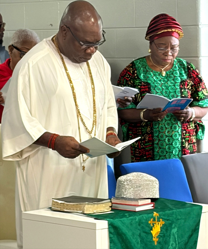 Igwe singing a hymn alongside a member of the congregation