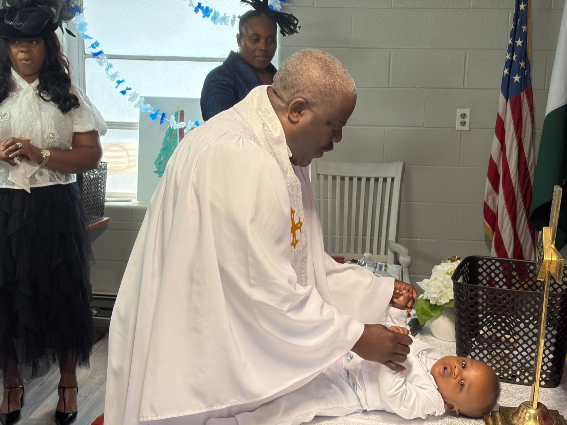 The priest tenderly anoints the child