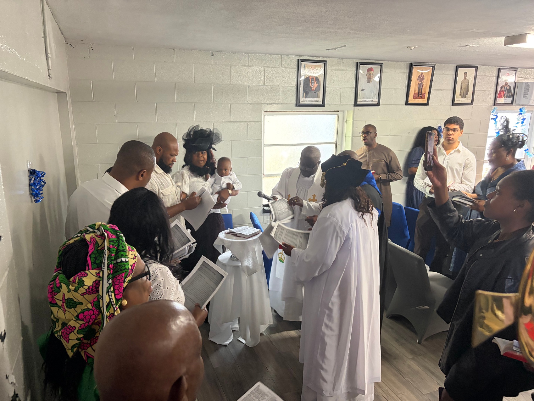 The congregation gathers around the family for the dedication service